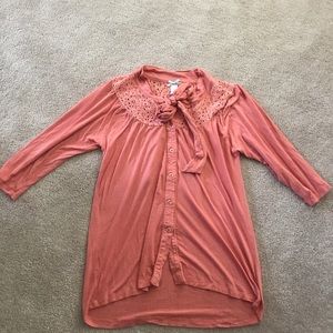 Coral colored top with buttons, lace, and tie
